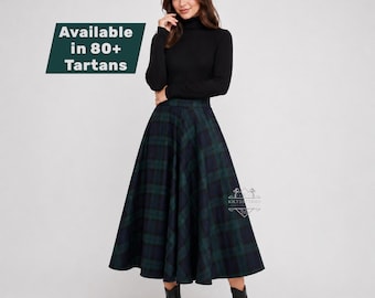 May include: A black long-sleeve turtleneck sweater paired with a floor-length, high-waisted A-line skirt featuring a dark green and navy blue plaid tartan pattern. A text overlay in the upper left corner states: Available in 80+ Tartans.