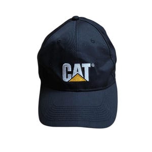 Peut inclure: Une casquette de baseball noire avec le texte brodé CAT en blanc et un accent triangulaire jaune sous la lettre A. La casquette présente une calotte structurée, une visière incurvée avec des surpiqûres et un bouton au sommet de la calotte.