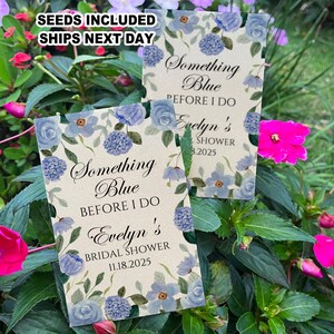 May include: Two blue and white floral patterned cards with the text "Something Blue Before I Do" and the bride's name and shower date. The cards are for a bridal shower.