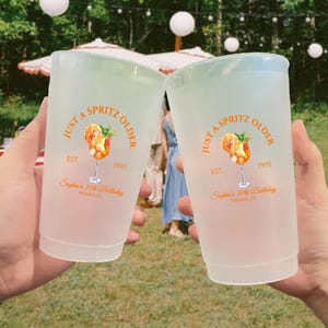 May include: Two frosted plastic cups with a light green rim, each bearing the text "Just a Spritz Older" and a cocktail illustration. The cups are personalized with "Sophia's 30th Birthday" and the year 1995.