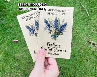 May include: Two kraft paper cards with blue and white floral designs and the text "Something Blue Before I Do" and "Evelyn's Bridal Shower 11.18.2026".