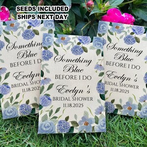 May include: Three blue and white floral patterned seed packets with the text "Something Blue Before I Do" and "Evelyn's Bridal Shower" with the date "11.18.2025".