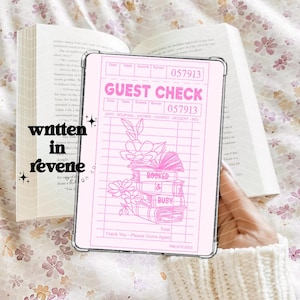 May include: A pink and white guest check with a pink outline. The check has a grid pattern and the text "GUEST CHECK" at the top. The check also has a drawing of a stack of books with flowers and the text "BOOKED & BUSY".