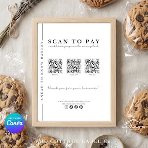 May include: A framed sign for a bakery with the text "SCAN TO PAY" and QR codes for PayPal, Cash App, and Venmo. The sign is surrounded by chocolate chip cookies in clear packaging and dried lavender.