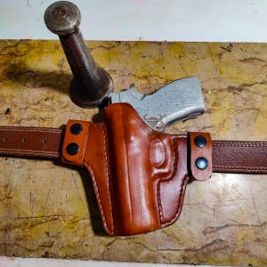 Funda de cuero Smith and Wesson OWB con parte superior abierta.