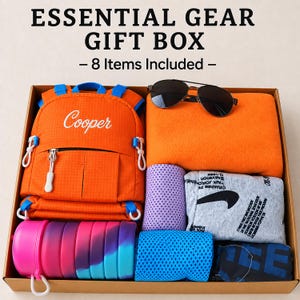 May include: An orange backpack with the name Cooper, a pair of black sunglasses, an orange fleece blanket, a purple cooling towel, a grey graphic t-shirt, a blue cooling towel, a dark blue shirt, and a pink and blue collapsible water bottle.