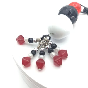 White, black and red bespoke bag charm.
