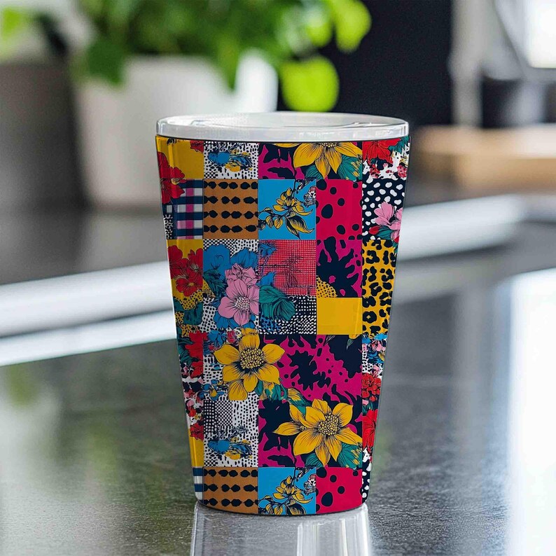K&ouml;nnte beinhalten: Ein hoher, farbenfroher Becher mit wei&szlig;em Rand. Die Au&szlig;enseite des Bechers ist ein Patchwork aus lebendigen Mustern, darunter Blumendesigns, Tupfen und Leopardenmuster, in Gelb-, Rosa-, Blau- und Rott&ouml;nen. Der Becher ist wahrscheinlich aus Keramik oder einem &auml;hnlichen Material.