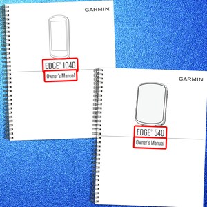 May include: Two white spiral-bound owner's manuals with black text and line art illustrations. The top manual is labeled Garmin Edge 1040 Owner's Manual, and the bottom manual is labeled Garmin Edge 540 Owner's Manual, both featuring red rectangular borders.