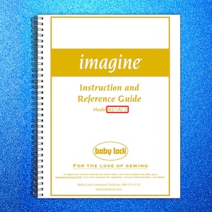 May include: A white spiral-bound instruction and reference guide with the word "imagine" in gold. The guide includes the Baby Lock logo and the text "FOR THE LOVE OF SEWING". The model number is BLE1AT-2.