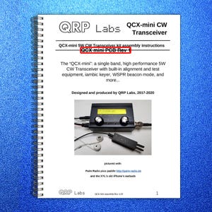 May include: A spiral-bound manual with the title "QRP Labs QCX-mini CW Transceiver." The manual includes assembly instructions and a photo of the transceiver, earbuds, and a paddle. The text reads "QCX-mini PCB Rev 1."