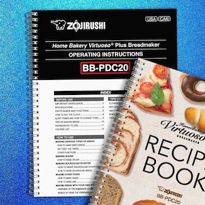 May include: A spiral-bound Zojirushi Home Bakery Virtuoso Plus breadmaker operating instructions manual and recipe book. The cover of the manual is black with white text, and the recipe book features images of baked goods.