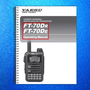 May include: A Yaesu FT-70DR digital/analog transceiver with an operating manual. The manual is spiral-bound and features the text "FT-70DR FT-70DE Operating Manual." The radio displays "446.500" on its screen.