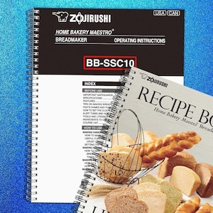 May include: A Zojirushi Home Bakery Maestro breadmaker instruction manual and recipe book. The instruction manual is black and white with the model number BB-SSC10. The recipe book shows various types of bread.