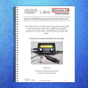 May include: A spiral-bound instruction manual for the QRP Labs QCX-mini CW Transceiver. The cover features the title, a description of the 5W transceiver, and a photograph showing the device connected to a Palm Radio pico paddle and white earbuds.