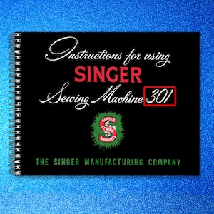 May include: A black spiral-bound manual titled "Instructions for using SINGER Sewing Machine 301." The cover features white script and red text, with a Singer logo and the text "THE SINGER MANUFACTURING COMPANY" in green.