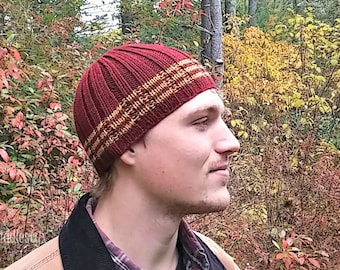 May include: A PDF pattern for a knitted hat with a burgundy body and gold stripes. The pattern includes instructions to make the hat yourself. The image shows a person wearing the hat.