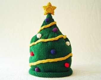 May include: A knitted Christmas tree hat pattern. The pattern is for a green hat with yellow yarn wrapped around it, and a yellow star on top. The hat is decorated with colorful ornaments.
