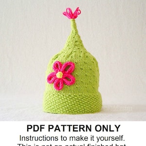 May include: A green knitted hat with a pink flower and a pink pom-pom on top.  PDF PATTERN ONLY. Instructions to make it yourself. This is not an actual finished hat.