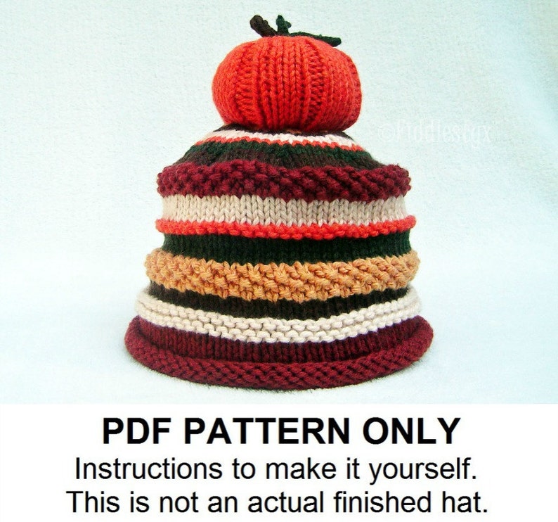 Puede incluir: Un patr&oacute;n de tejido PDF para un gorro a rayas con una calabaza roja tejida en la parte superior. El gorro est&aacute; hecho con una variedad de colores, incluyendo rojo, blanco, verde y marr&oacute;n. El patr&oacute;n incluye instrucciones para hacer el gorro t&uacute; mismo.  PDF PATTERN ONLY. Instructions to make it yourself. This is not an actual finished hat.