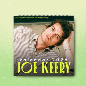 Puede incluir: Calendario de 2026 con una fotografía de Joe Keery. El calendario tiene una encuadernación en espiral y el texto «You just gotta live your life and do it your way». El nombre «JOE KEERY» está impreso en letras grandes y amarillas.