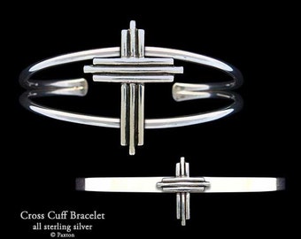 May include: A silver cuff bracelet with a geometric cross design. The bracelet is made of sterling silver and is a simple, elegant piece of jewelry.