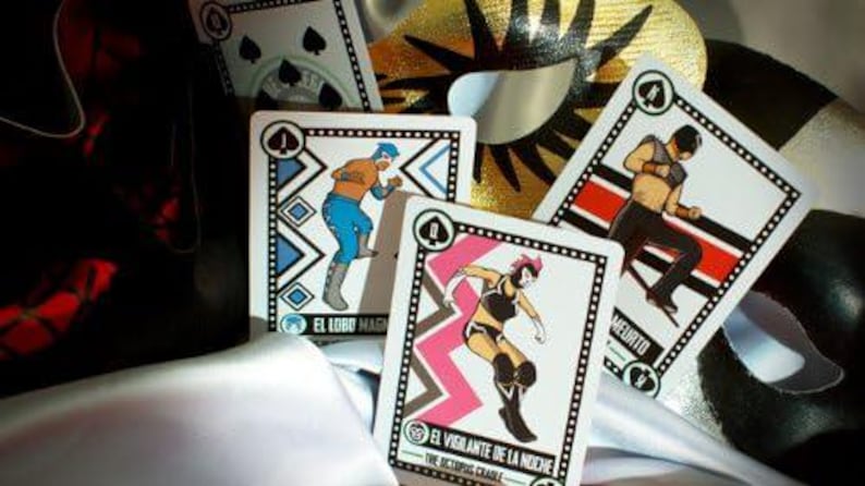 Op de afbeelding: Vier speelkaarten met illustraties van gemaskerde worstelaars. De kaarten zijn uit een deck genaamd "The Luchador Deck". De namen van de kaarten zijn "El Lobo Magico", "El Vigilante de la Noche", "Muerto" en "The Octopus Chameleon".
