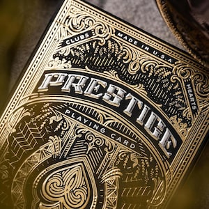 May include: A deck of "Prestige Playing Card" cards. The card box is black with gold filigree and the word "Prestige" in silver. The box also says "Made in U.S.A."