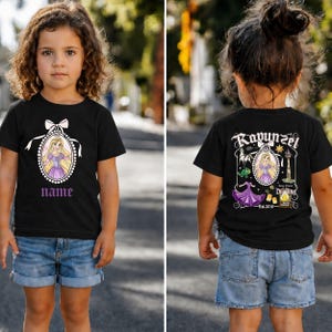 Puede incluir: Camiseta negra con un dise&ntilde;o de dibujos animados de una princesa en la parte delantera, con la palabra "name" en morado. La parte trasera de la camiseta tiene un dise&ntilde;o a juego con la palabra "Rapunzel" y el texto "Est. 2010".