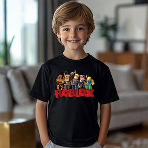 a young boy standing in front of a couch wearing a roblox shirt