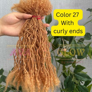 May include: A bundle of light brown synthetic dreadlocks with curly ends, tied together with a red band. The text "Color 27 With curly ends" is displayed on a yellow background.