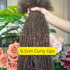 Peut inclure: Mèches de cheveux bouclés marron avec des pointes bouclées de 0,1 cm. Les cheveux sont tenus dans une main, avec un fond de feuilles vertes et de roses roses et rouges.