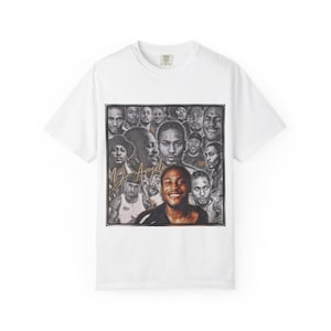 Può includere: T-shirt bianco con un collage di ritratti e un'immagine centrale di una persona sorridente. Il design include il testo "MJ Angelo" in corsivo dorato, creando un capo d'abbigliamento unico e artistico.
