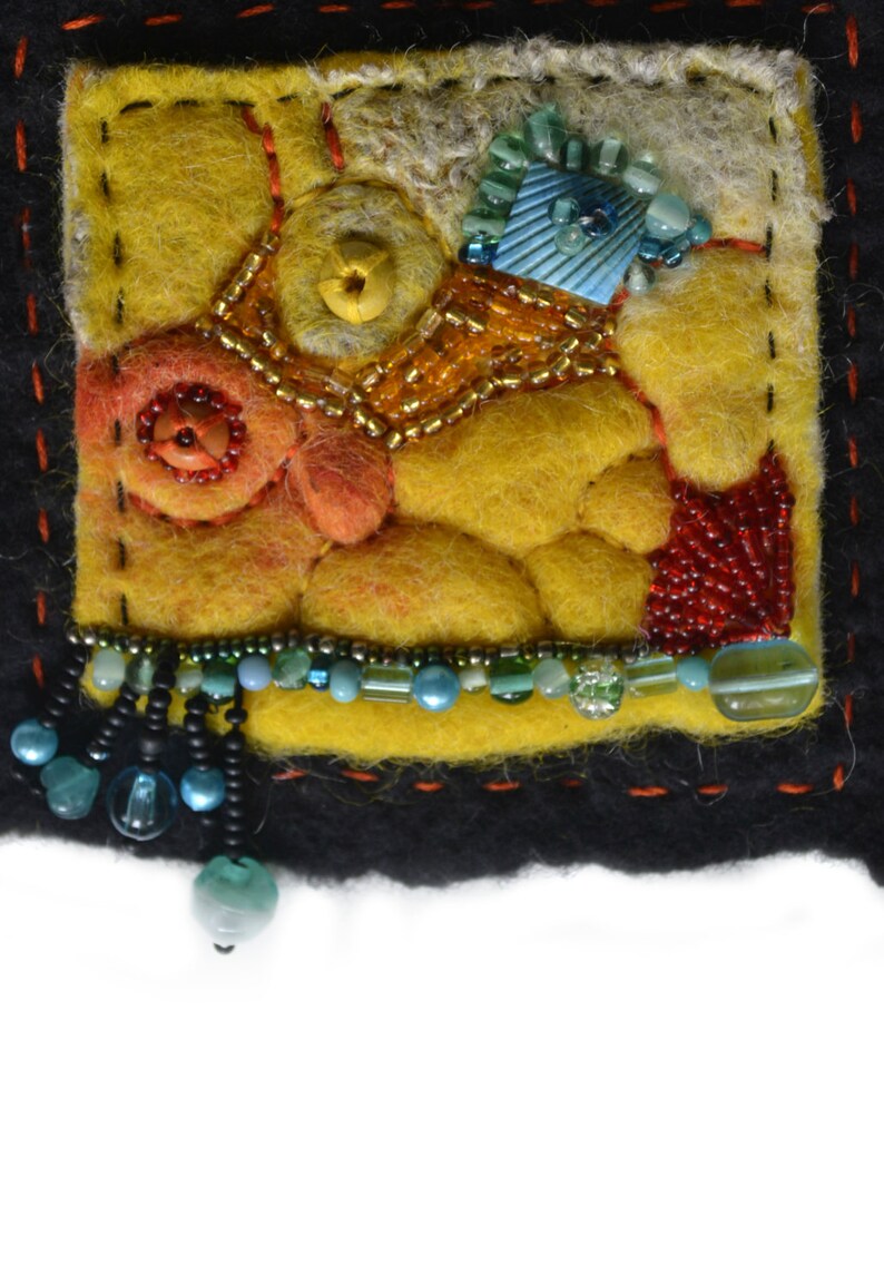 May include: A small, square, yellow felt piece with a variety of colourful beads and embroidery. The felt is stitched with black thread and has a black border. The piece has a fringe of black and blue beads.