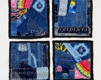 Pode incluir: Quatro peças quadradas de arte de tecido de retalhos de ganga azul com molduras pretas. Cada peça tem um design diferente e inclui várias texturas e cores, incluindo rosa, amarelo e branco.