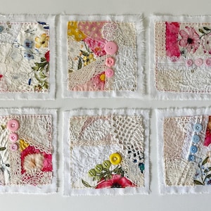 May include: Six square fabric patches featuring layered textiles, lace, and floral patterns. Each patch is embellished with small plastic buttons in various colors including pink, blue, yellow, and green, with frayed white edges on all sides.