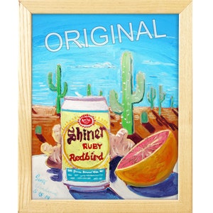 以下が含まれることがあります： 砂漠の風景の中に、シャイナー・ルビー・レッドバードビールの缶、グレープフルーツ、サボテンを描いた絵画。絵画の左下には「Gene Oakland 2-15-14」という署名がある。絵画の上部には「ORIGINAL」というタイトルが白い文字で書かれている。