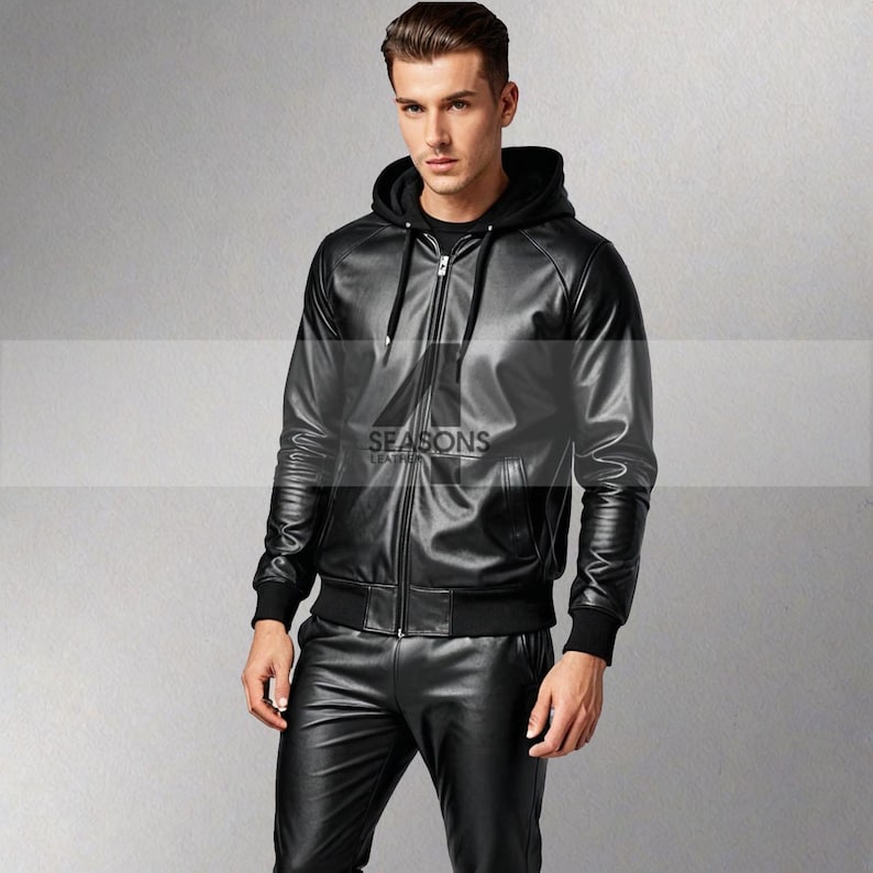 Puede incluir: Chaqueta con capucha de cuero negro con cremallera, pu&ntilde;os y dobladillo acanalados. El logo "SEASONS LEATHER" es visible. El modelo lleva pantalones de cuero negro. Una opci&oacute;n de abrigo elegante.