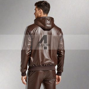 May include: A brown leather jacket with a hood and white stripes down the sleeves. The back of the jacket features the text "4 SEASONS LEATHER" in black. The jacket is part of a matching leather tracksuit.