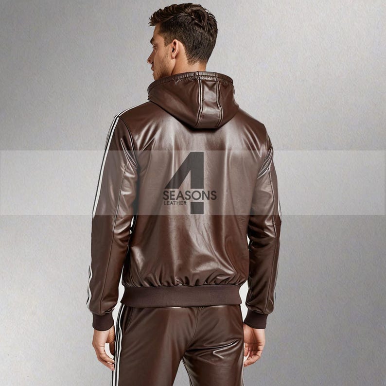May include: A brown leather jacket with a hood and white stripes down the sleeves. The back of the jacket features the text "4 SEASONS LEATHER" in black. The jacket is part of a matching leather tracksuit.