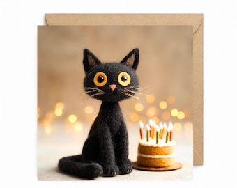 May include: A black cat figurine with large yellow eyes and whiskers sits next to a small birthday cake with lit candles. The cat is on a greeting card with a brown envelope.