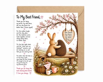 May include: A square greeting card with a brown envelope featuring an illustration of a tan rabbit and a brown hedgehog sitting on a wooden bench under a flowering tree. A heart-shaped sign hangs from a branch with text and a basket sits nearby.