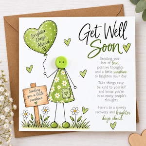 May include: A square greeting card featuring a green button character holding a heart-shaped balloon with the text Brighter Days Ahead. The card includes a wooden sign reading Sending you a little sunshine and the text Get Well Soon.