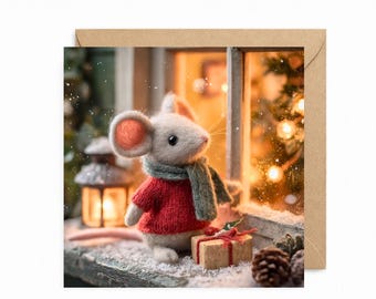 May include: A felted mouse figurine wearing a red knitted sweater and a green scarf, standing on a snowy ledge next to a small gift box wrapped with red twine, a pinecone, and a glowing lantern, with a blurred window and lights in the background.