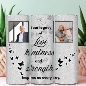 May include: A personalized tumbler with a glittery silver background. It features two framed photos of an older couple and a man. The text reads "Your legacy of Love kindness and strength inspires us every day." Black butterfly accents.
