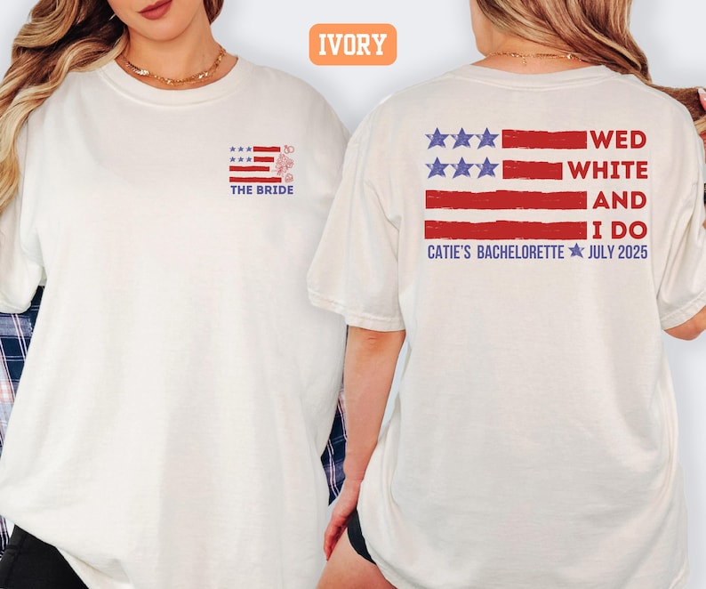 May include: Ivory-colored t-shirt with a patriotic design. The front features a small American flag graphic with the text "THE BRIDE." The back displays a larger flag design with the words "WED WHITE AND I DO" and "CATIE'S BACHELORETTE JULY 2025."