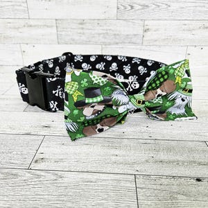 May include: Black and white dog bone patterned dog collar with a green, white, and black bow tie featuring a dog wearing a leprechaun hat.