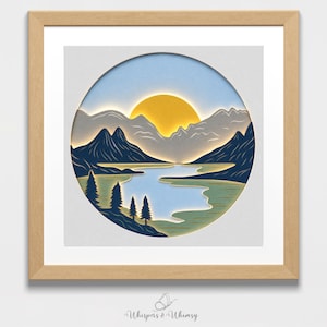 May include: A square framed wall art piece featuring a circular layered paper cutout of a mountain landscape. The scene depicts a bright yellow sun over grey mountains, a blue lake, and dark blue pine trees. The text Whispers & Whimsy is below.