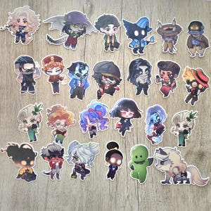 May include: A collection of twenty-three individual die-cut stickers featuring various chibi-style characters with diverse hair colors, outfits, and expressions, including humanoids, creatures, and a wolf-like figure, all with white borders.