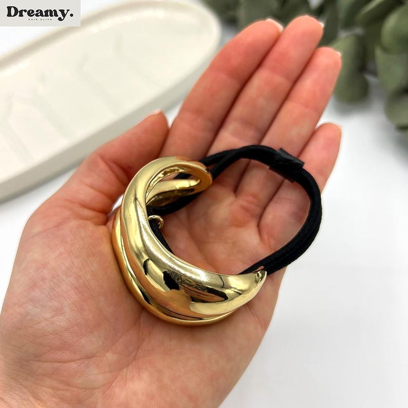 Pu&ograve; includere: Coda di cavallo dorata con elastico nero. Il pezzo dorato &egrave; un design a doppio anello.